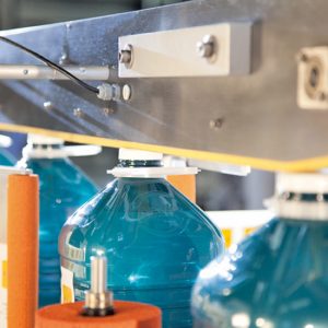 Wasserkanister durchlaufen die Eti5 Modular Seiten-Etiekettiermaschine